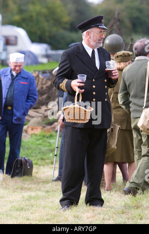 Funzionario in uniforme tenendo un cestello e la pinta di birra Foto Stock