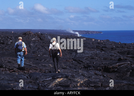 Visitatori escursione su flussi di lava a nuova eruzione sito, Parco Nazionale dei Vulcani delle Hawaii Foto Stock