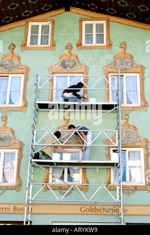 Gruppo di uomini donna restauratore al lavoro sulla facciata tradizionale Lueftlmalerei pittura a Bad Toelz Baviera Germania Foto Stock