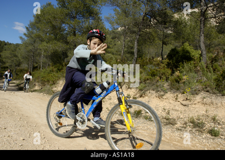 Francia Provenza Vitrolles ragazzo di giovani e adulti a cavallo le loro mountain bike su una strada sterrata Foto Stock