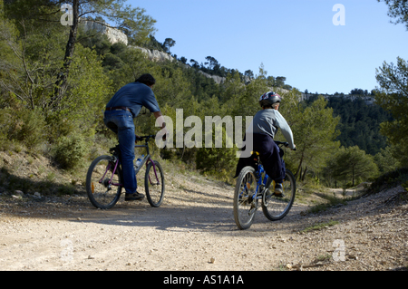 Francia Provenza Vitrolles ragazzo di giovani e adulti a cavallo le loro mountain bike su una sporcizia Foto Stock