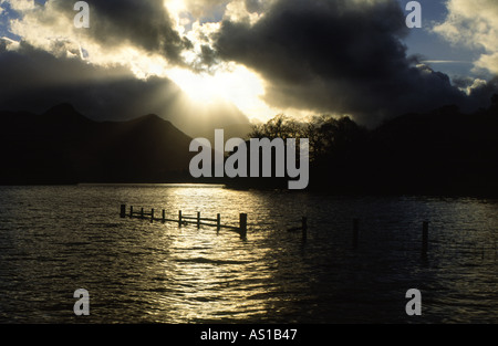 Fasci di luce divergente da dietro una nuvola sulla Derwent Water Lake District Inghilterra REGNO UNITO Foto Stock