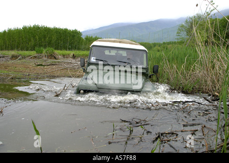 Anestis Rekkas guida la sua Land Rover 90 attraverso il fiume Foto Stock