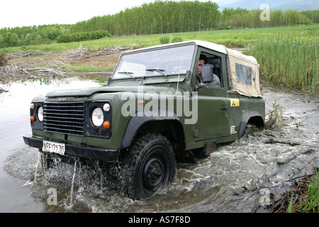 Anestis Rekkas guida la sua Land Rover 90 attraverso il fiume Foto Stock