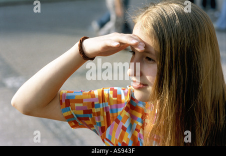 Ragazza giovane che copre gli occhi cercando in futuro faccia verticale Foto Stock