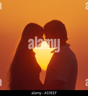 Giovane coppia adolescenti abbracciando al tramonto Foto Stock