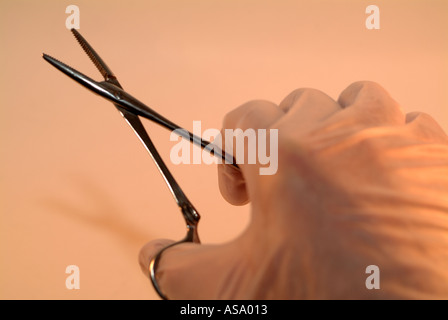 La mano di presa di un paio di pinze chirurgiche Foto Stock