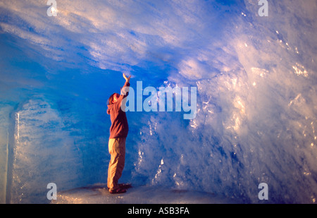 Tourist all'interno di una caverna di ghiaccio del ghiacciaio del Rodano, Vallese, alpi svizzere, Svizzera Foto Stock