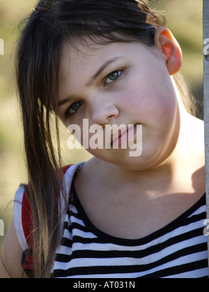 Ragazza cerca nella fotocamera, con le guance rosa e un misero aspetto sul suo viso Foto Stock