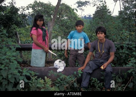 Cewa famiglia siede sul pipline che attraversa la loro terra in Amazzonia ecuadoriana America del Sud Foto Stock