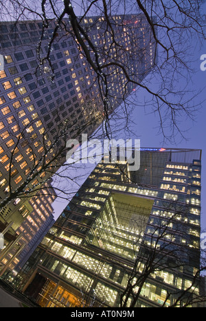 Verticale ampia angolazione del Canary Wharf Tower e Canada Square Park con l'ufficio luci accese di sera Foto Stock