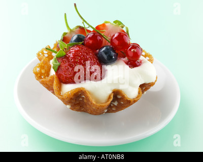 Il Brandy snap cesto di frutta fresca e crema di latte Foto Stock