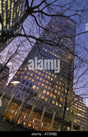 Verticale ampia angolazione del Canary Wharf Tower e Canada Square Park con l'ufficio luci accese di sera Foto Stock