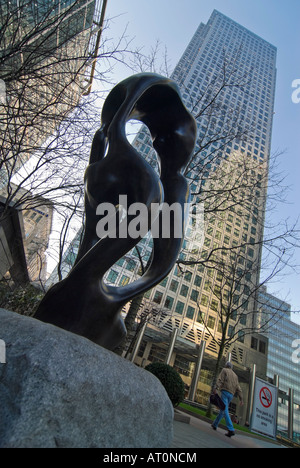 Verticale ampia angolazione del Canary Wharf Tower e Canada Square Park su una luminosa giornata soleggiata con una scultura moderna in primo piano Foto Stock