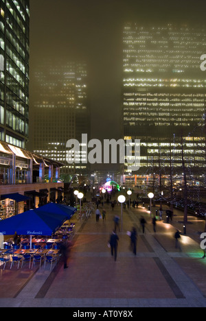 Antenna verticale ampio angolo di Reuters posto a Canary Wharf con pendolari rushing home su una nebbia inverni di notte. Foto Stock