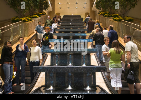 ILLINOIS Chicago persone a cavallo delle scale mobili in Water Tower Place Mall interno fontana nel centro schizzi di acqua Foto Stock