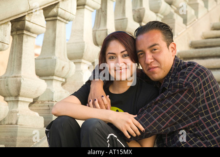Messico Guanajuato giovane uomo e donna seduta vicino insieme sui passi le braccia intorno a lei felice e in amore sorridente Foto Stock
