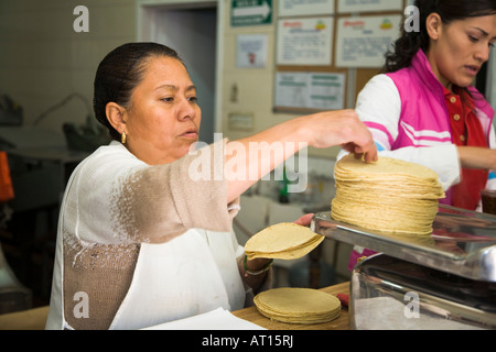 Messico Guanajuato donna pesare pila di tortillas su scala in piccole tortilla rendendo shop Foto Stock