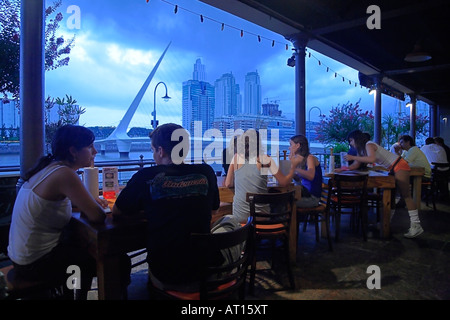 I giovani godono presso un bar a Puerto Madero Docks, appena di fronte Calatrava 's ponte della donna. Buenos Aires, Arg. Foto Stock