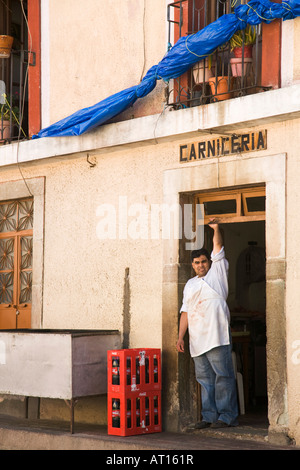 Messico Guanajuato macellaio maschio con grembiule sanguinosa in piedi nella porta del negozio di macellaio carcineria segno sopra le porte Foto Stock