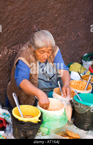 Messico Guanajuato vecchi donna messicana con i capelli bianchi di incavature cibo dalle benne su strada Foto Stock
