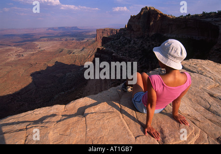 Donna seduta sulla cima della Mesa Arch, il Parco Nazionale di Canyonlands, Utah, Stati Uniti d'America Foto Stock