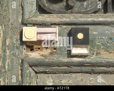 Due campanelli di porte su una vecchia porta di legno Foto Stock