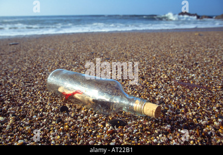 Un messaggio in bottiglia lavato fino a una spiaggia Foto Stock