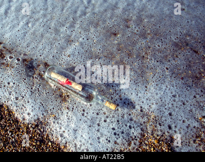 Un messaggio in bottiglia lavato fino a una spiaggia Foto Stock