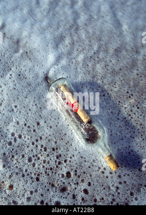 Un messaggio in bottiglia lavato fino a una spiaggia Foto Stock