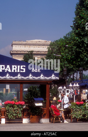 Parigi cafe bar ristorante con cameriere e clienti a Champs Elysees con Arc de Triomphe in background Parigi Francia Foto Stock