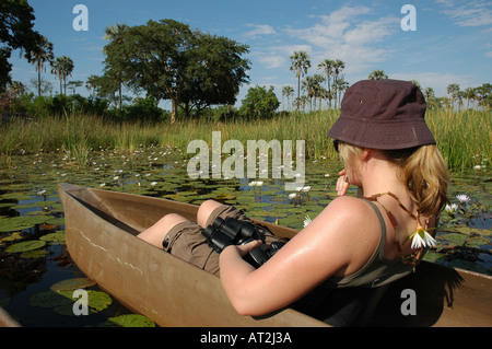 Ragazza in turistica Mokoros sul fiume vicino Tubu tree safari camp di Okavango Delta Botswana southern Afr Foto Stock