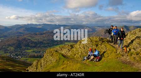 Walkers gustano la vista dalla cima di Wansfell, con Ambleside e Lakeland montagne sullo sfondo. Lake District UK Foto Stock