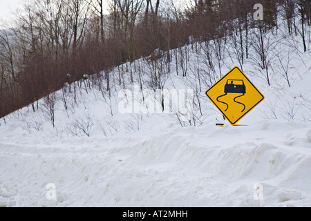 Strada sdrucciolevole segno coperte da neve Foto Stock