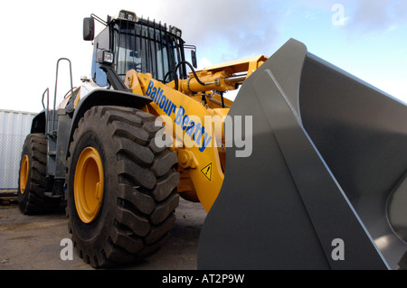 Una grande massa di scavo mover jcb escavatore di proprietà di Balfour beatty costruzione su un sito di costruzione con grandi ruote e pneumatici Foto Stock