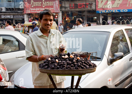 Indian uomo vendita dado Singhara (Trapa natans)(il castagno d'acqua), la Vecchia Delhi, India Foto Stock