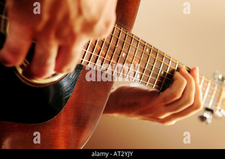 Le mani di una persona suonando una chitarra acustica Foto Stock