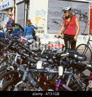 Una donna l'acquisto di una bicicletta a Brick Lane il mercato delle pulci di domenica mattina London REGNO UNITO Foto Stock