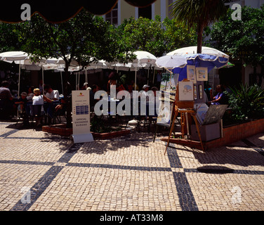 Estate scena di strada con outdoor cafe e artista pittura in Lagos, Algarve Portogallo Foto Stock