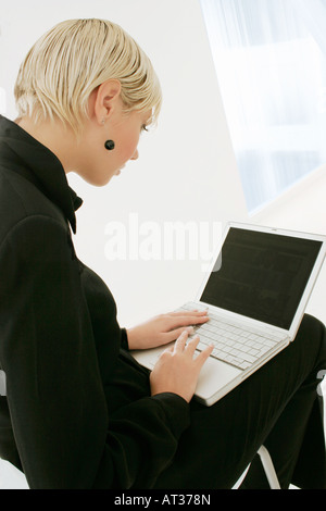 Un ben vestiti Donna al lavoro su un computer portatile Foto Stock