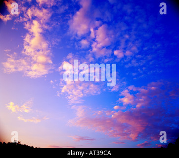 Sunrise diventa soffici nuvole bianche rosa nel cielo blu Foto Stock
