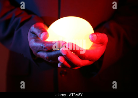 Un uomo con una luce ovale in entrambe le mani Foto Stock