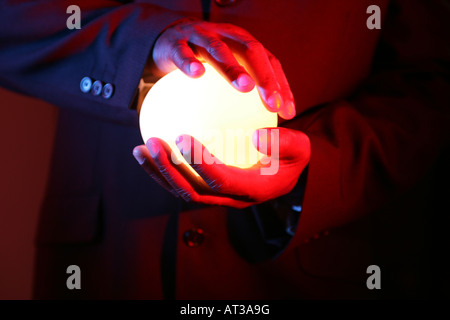 Un uomo con una luce ovale in-tra entrambe le mani Foto Stock