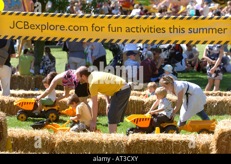 Un padre aiuta il suo bambino gioca su un giocattolo autocarro con cassone ribaltabile in corrispondenza del villaggio di innocenti FETE IN Regents Park Londra 2007 Foto Stock