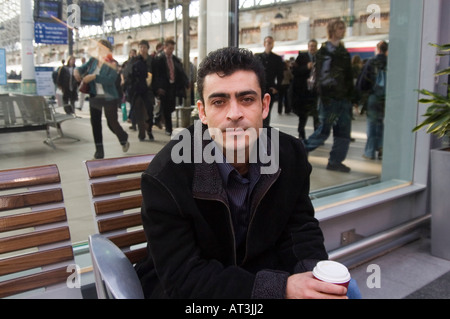 Annoiato uomo in attesa in una stazione ferroviaria Foto Stock