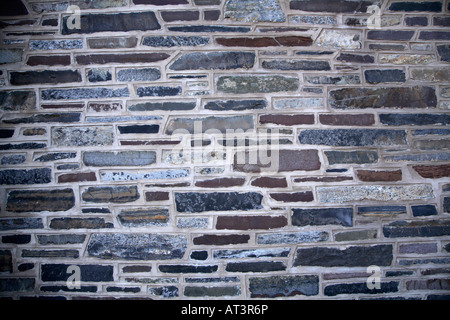 Variato muro di pietra. Piatto di pietre di forma oblunga in variabile larghezze e materiali con calcestruzzo di spessore intorno a loro. Foto Stock