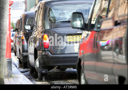 In attesa di riga nera hackey Londra trasporto taxi su un rango accanto al cordolo in Belfast City Centre Foto Stock