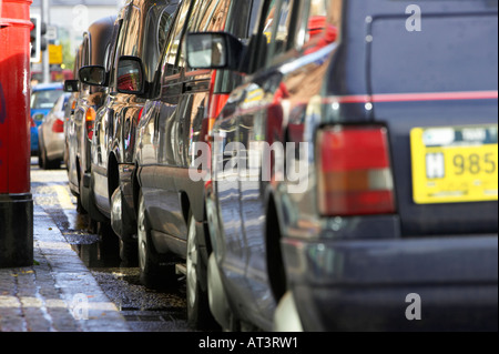 Fila di nero hackey Londra trasporto taxi su un rango accanto al cordolo in Belfast City Centre Foto Stock