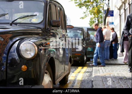 Fila di nero hackey Londra trasporto taxi su un rango in Belfast City Centre Foto Stock