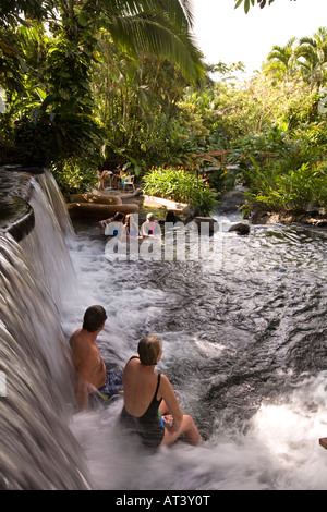 Costa Rica La Fortuna Tabacon Hot Springs Resort gli ospiti seduti sotto termicamente cascata riscaldato Foto Stock